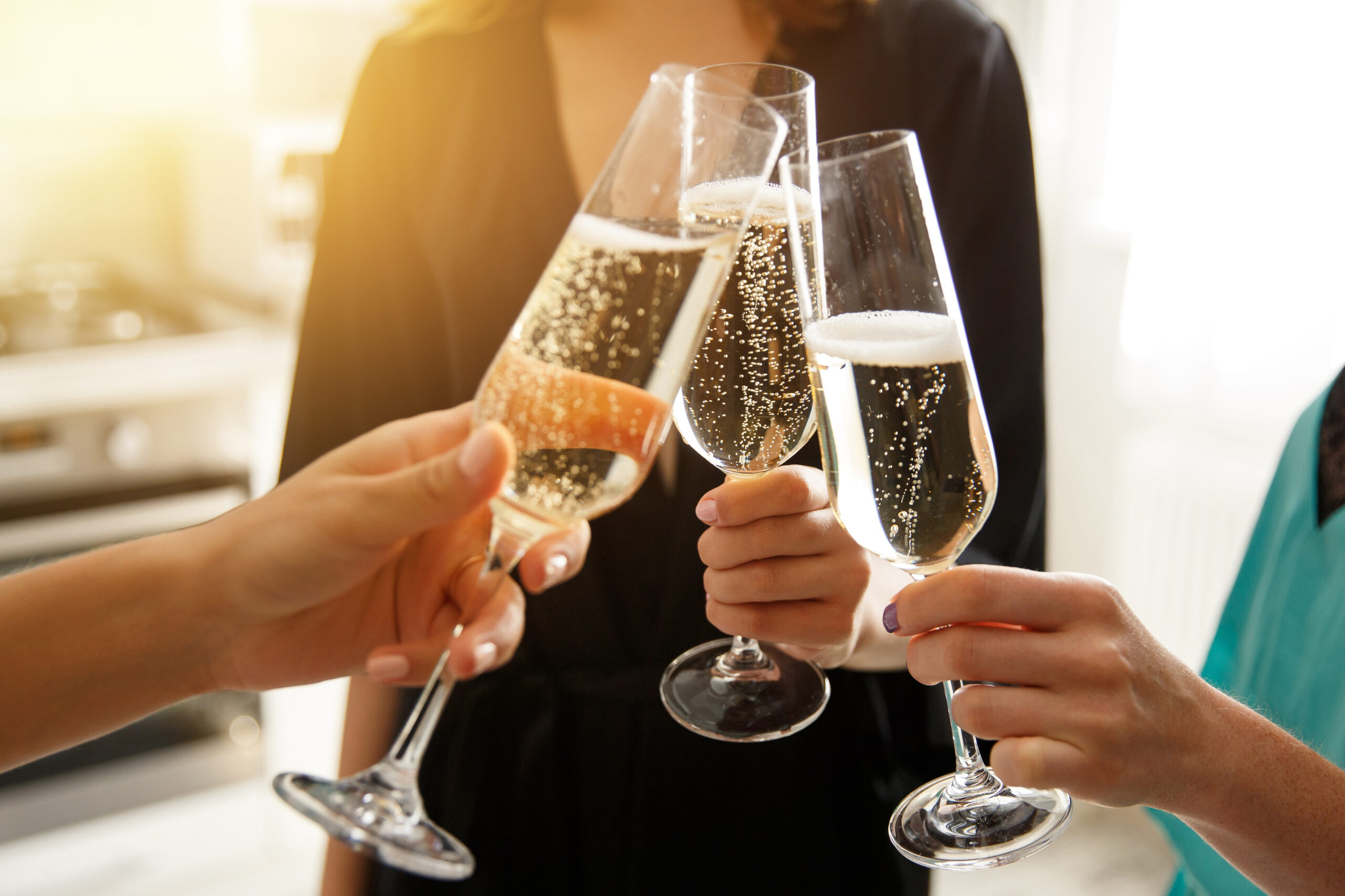 Group of young women cheering with champagne, celebrating merry christmas at home