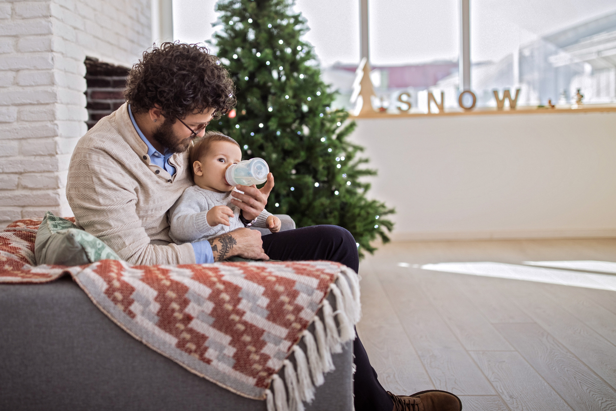 Dad feeding his baby on Christmas morning
