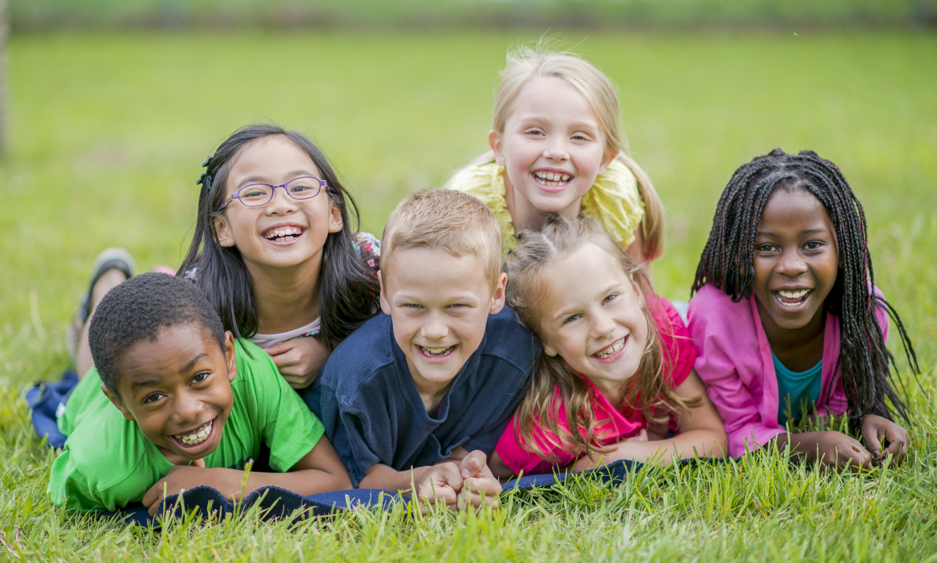 Happy children lying in the grass