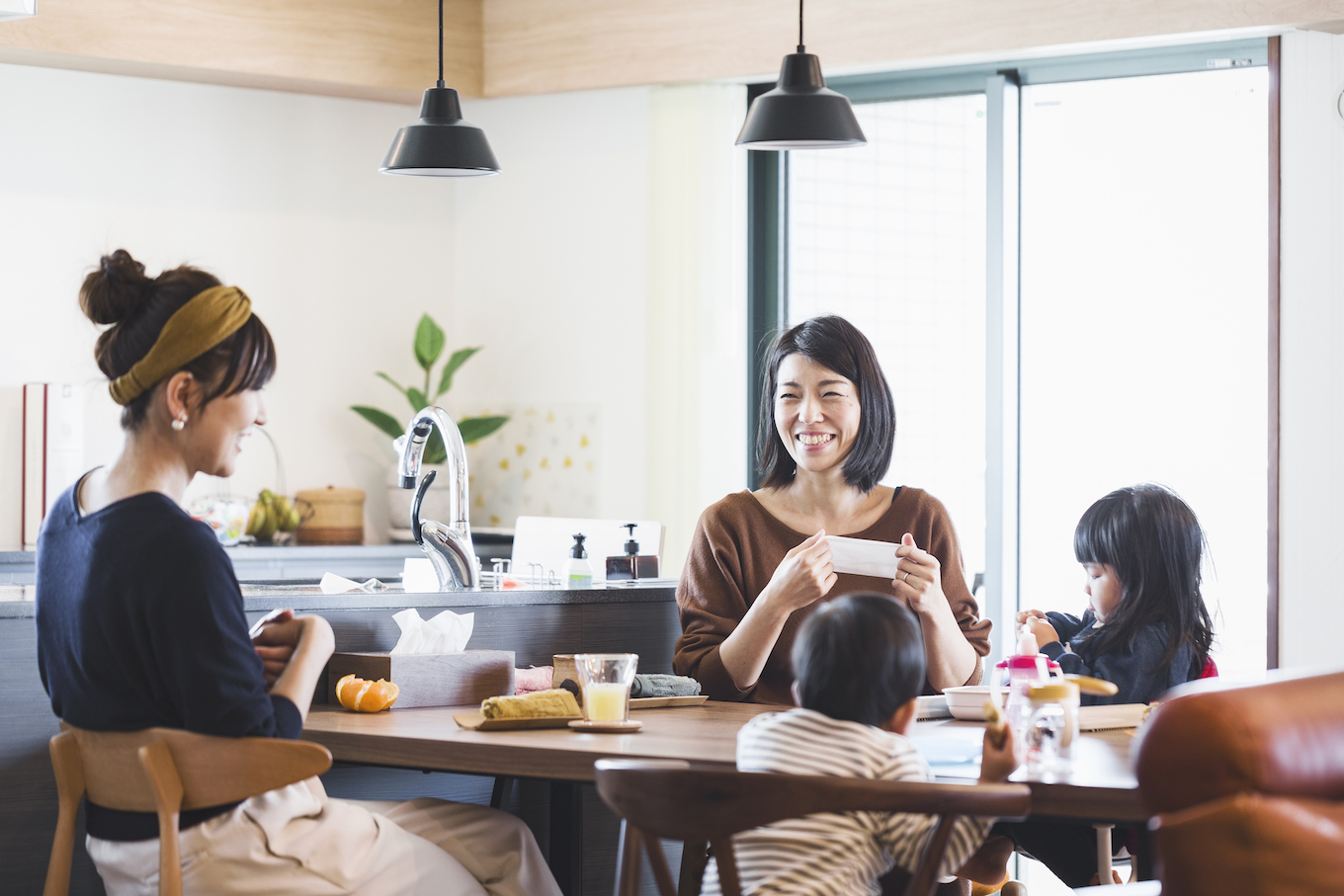 Mothers and kids having a snack on dining table