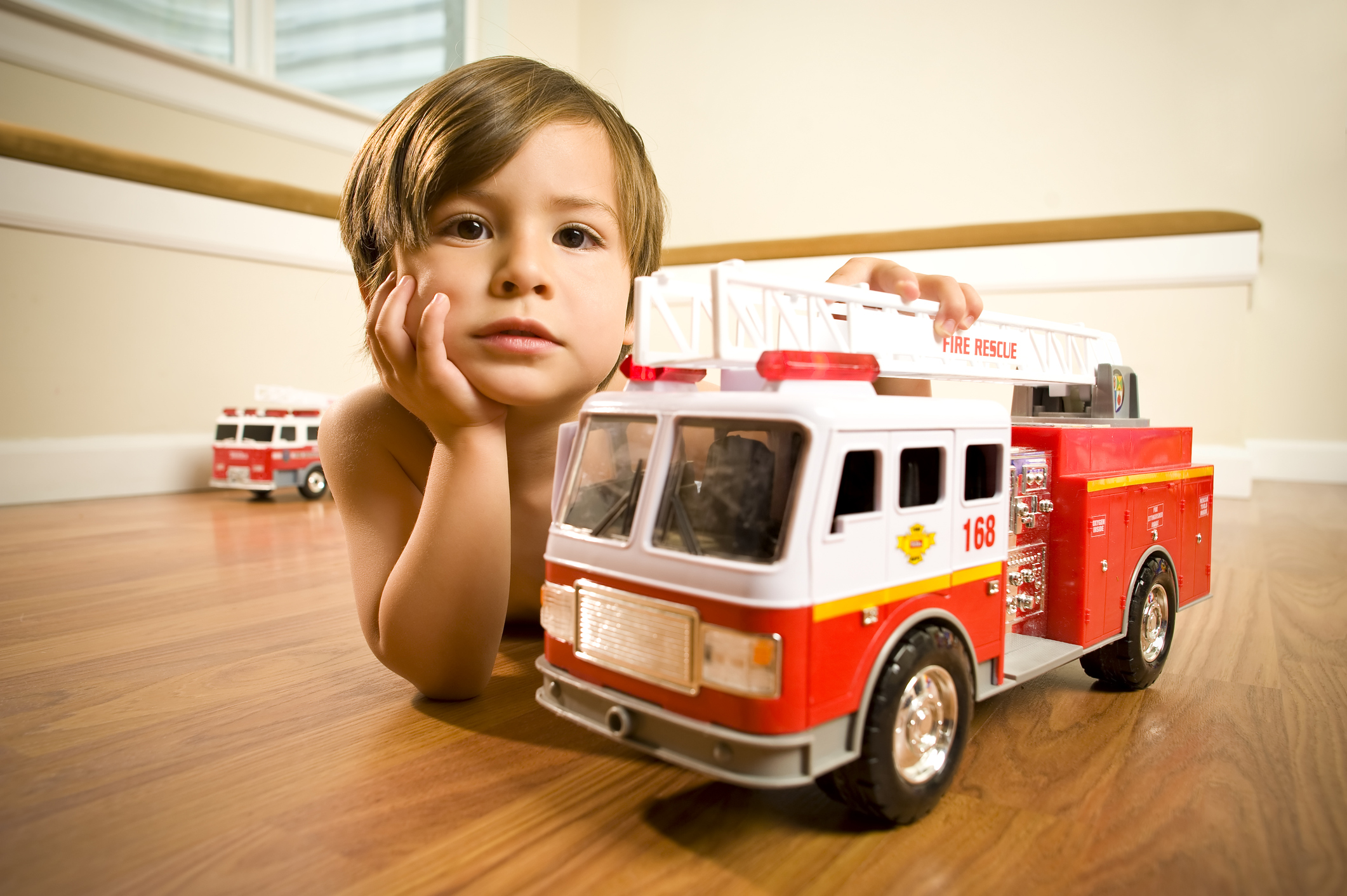 Boy with toy fire trucks
