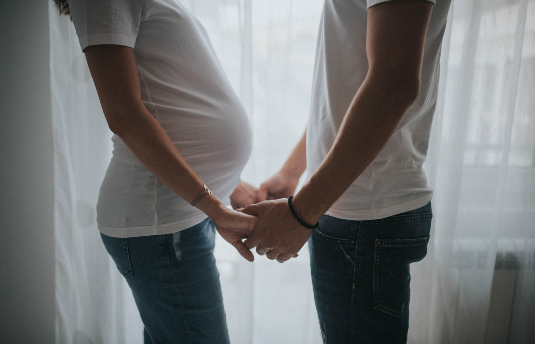 Pregnant woman holding man's hands