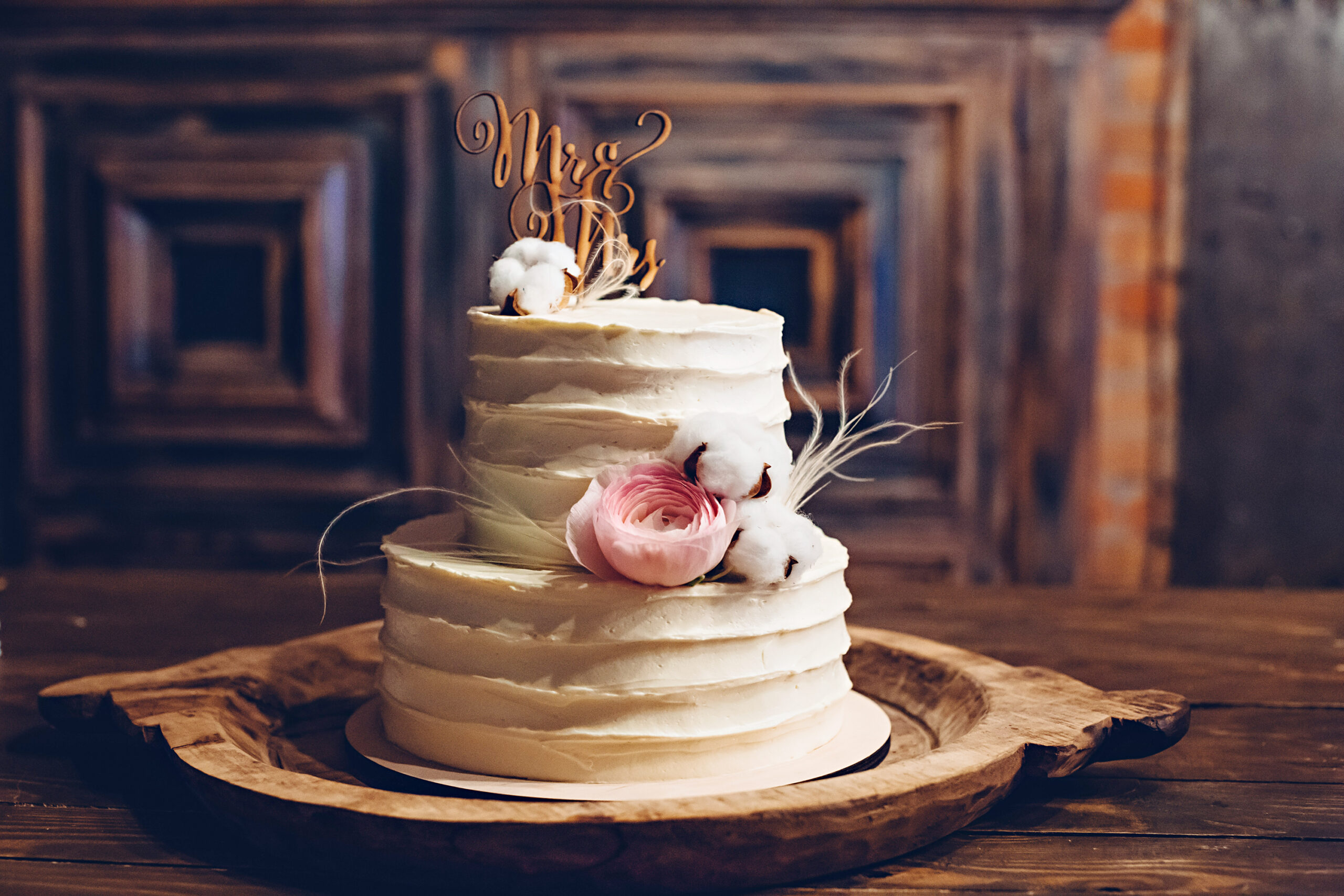 Rustic style wedding cake with cotton and floral decoration.