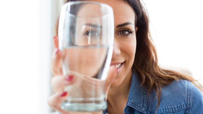 woman holding glass of water