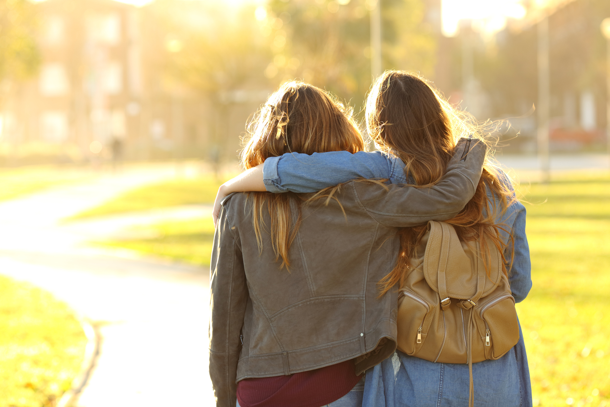 Affectionate friends walking at sunset in a park