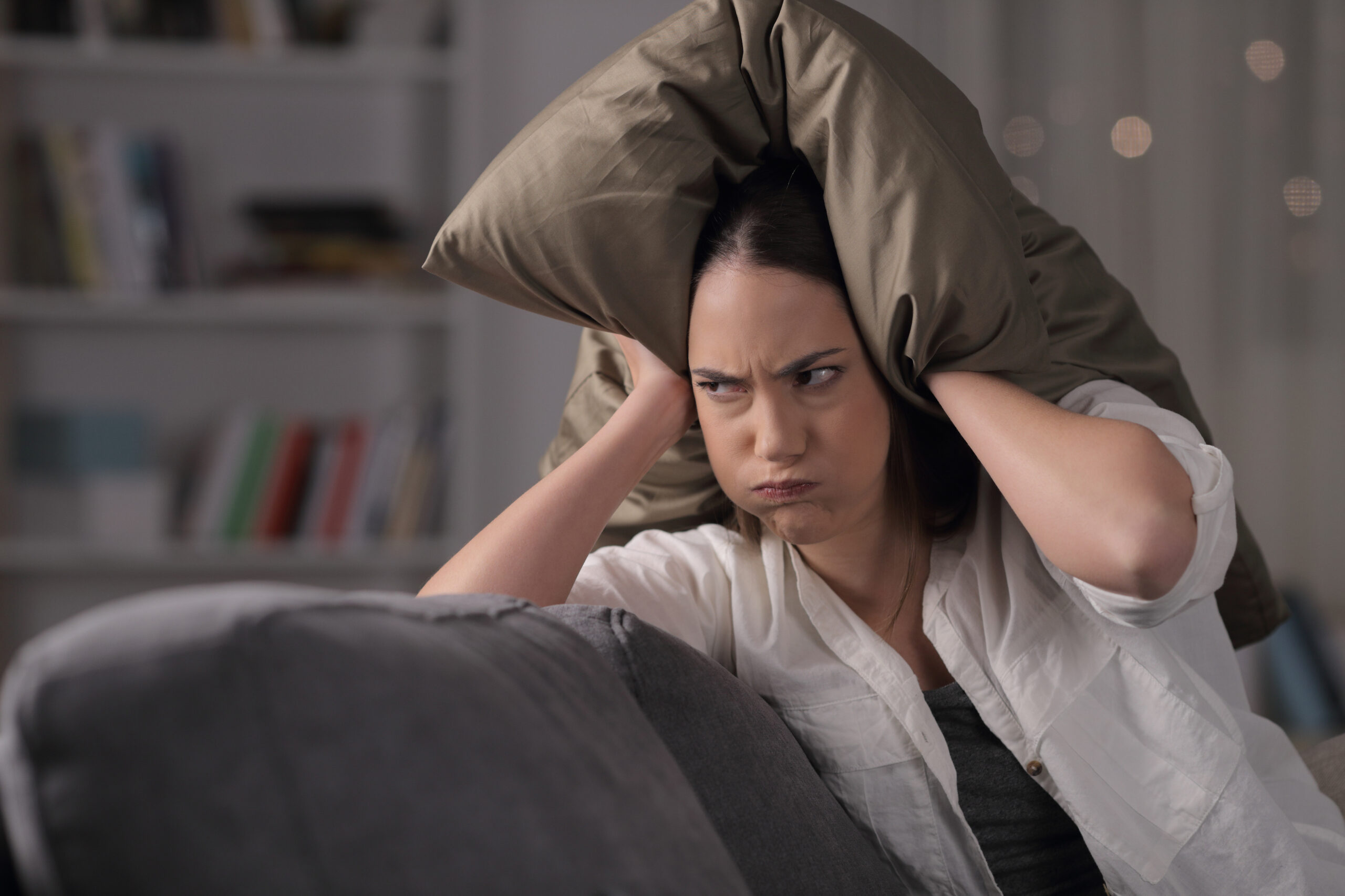 annoyed woman pillow over head
