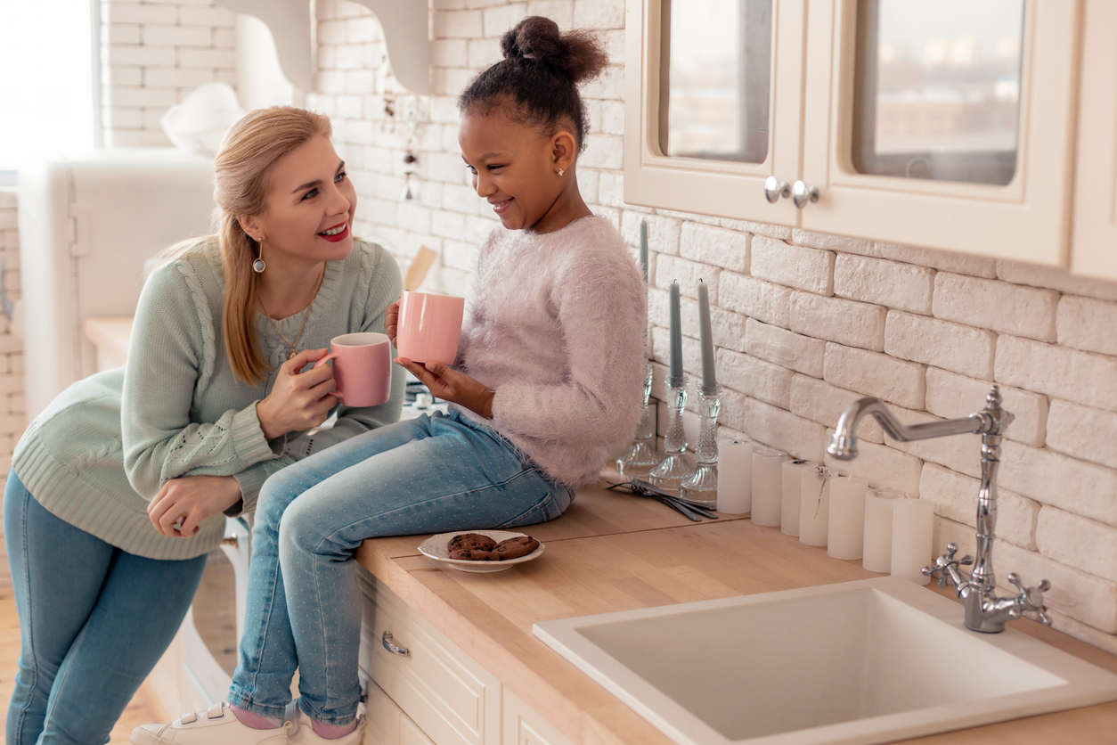 Loving mother feeling happy looking at her adopted daughter