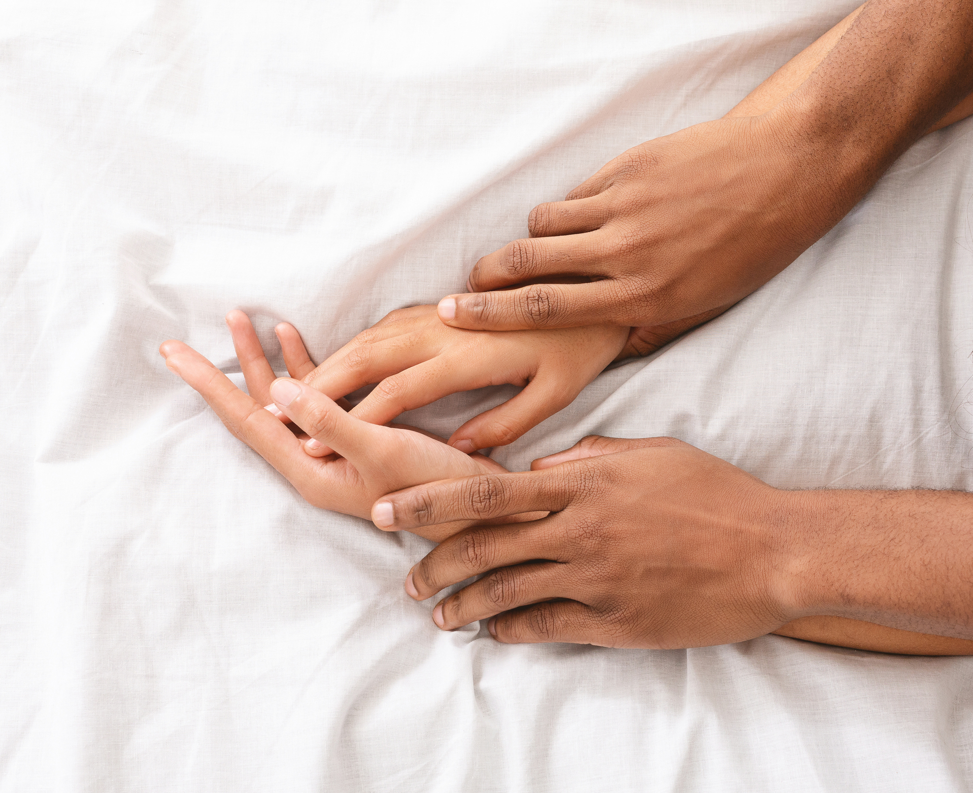 Man and woman hands having sex on bed