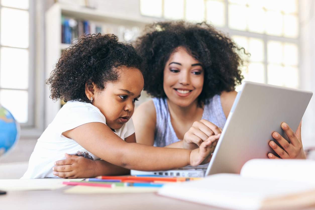 Young woman and a child pointing on laptop