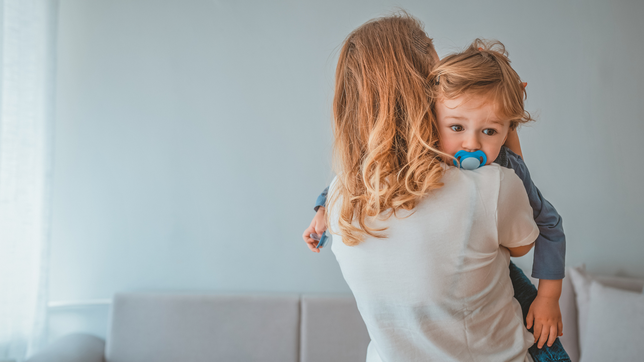 Mom holding child who has a pacifier