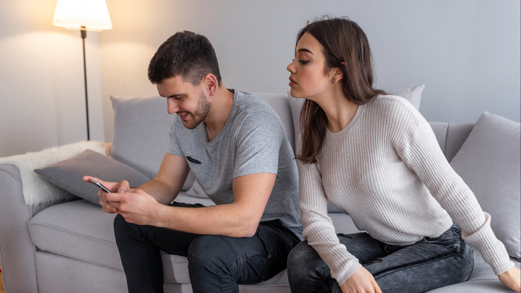 A woman watching a man on his phone
