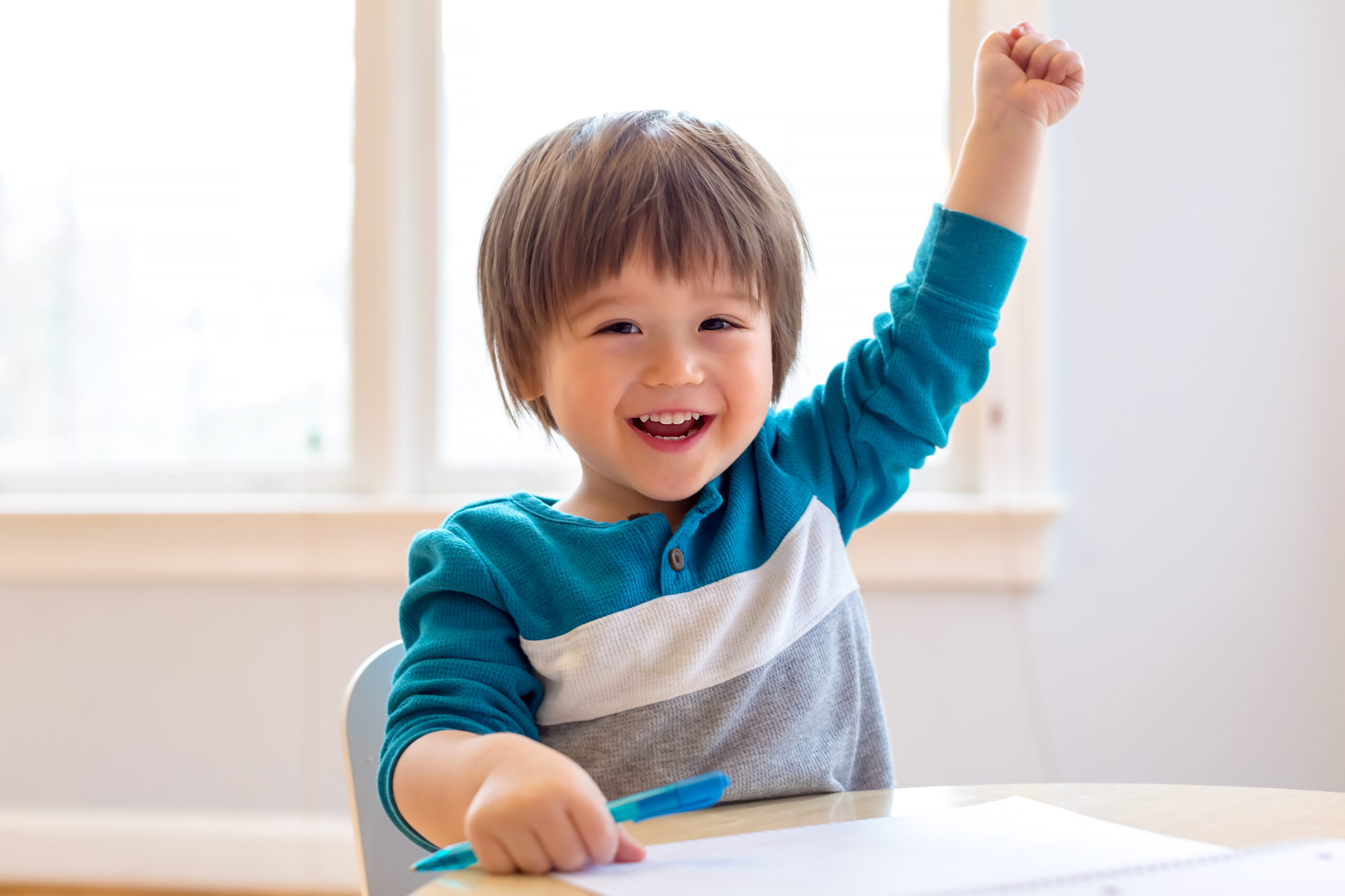 Happy toddler raising his hand