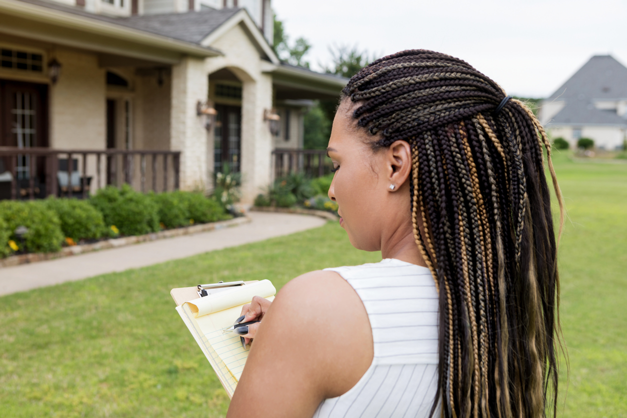 Mid adult realtor evaluates a property for sale