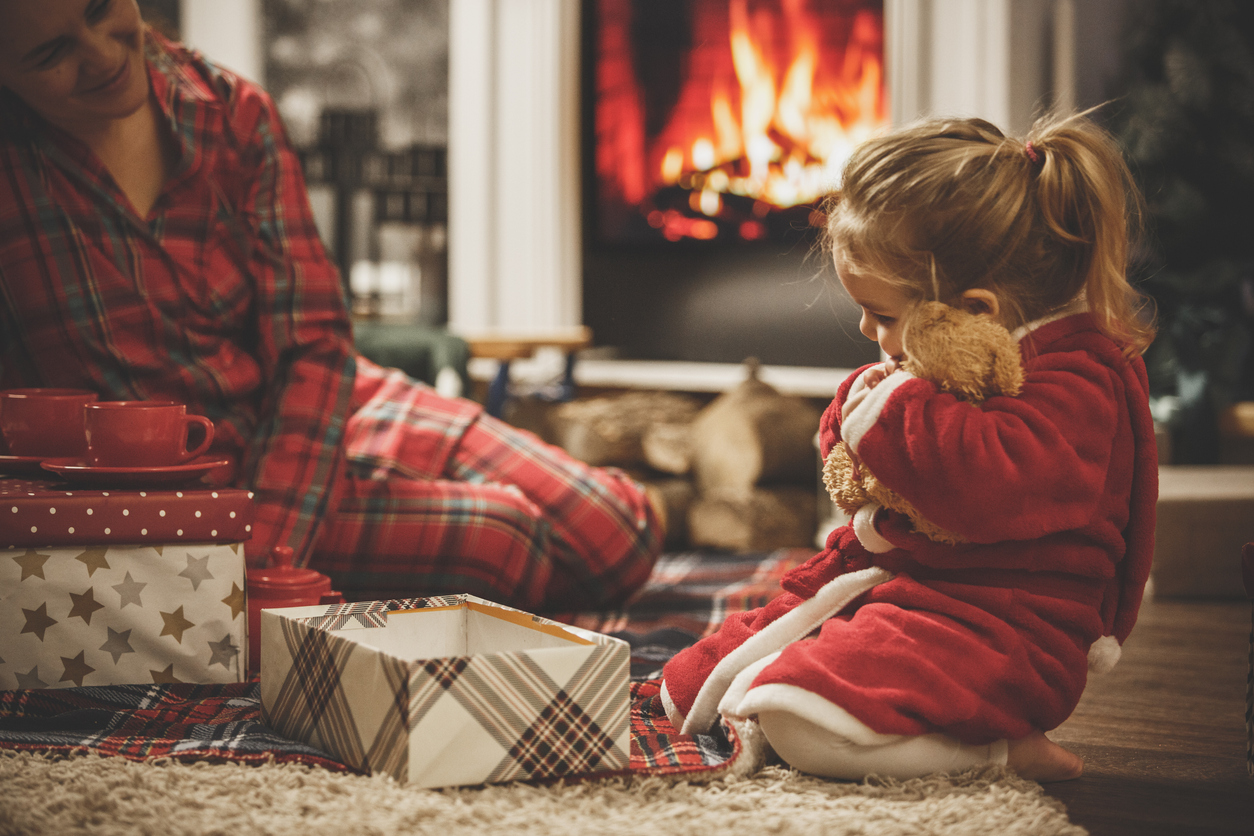 Little girl hugging her new teddy bear on a Christmas Eve