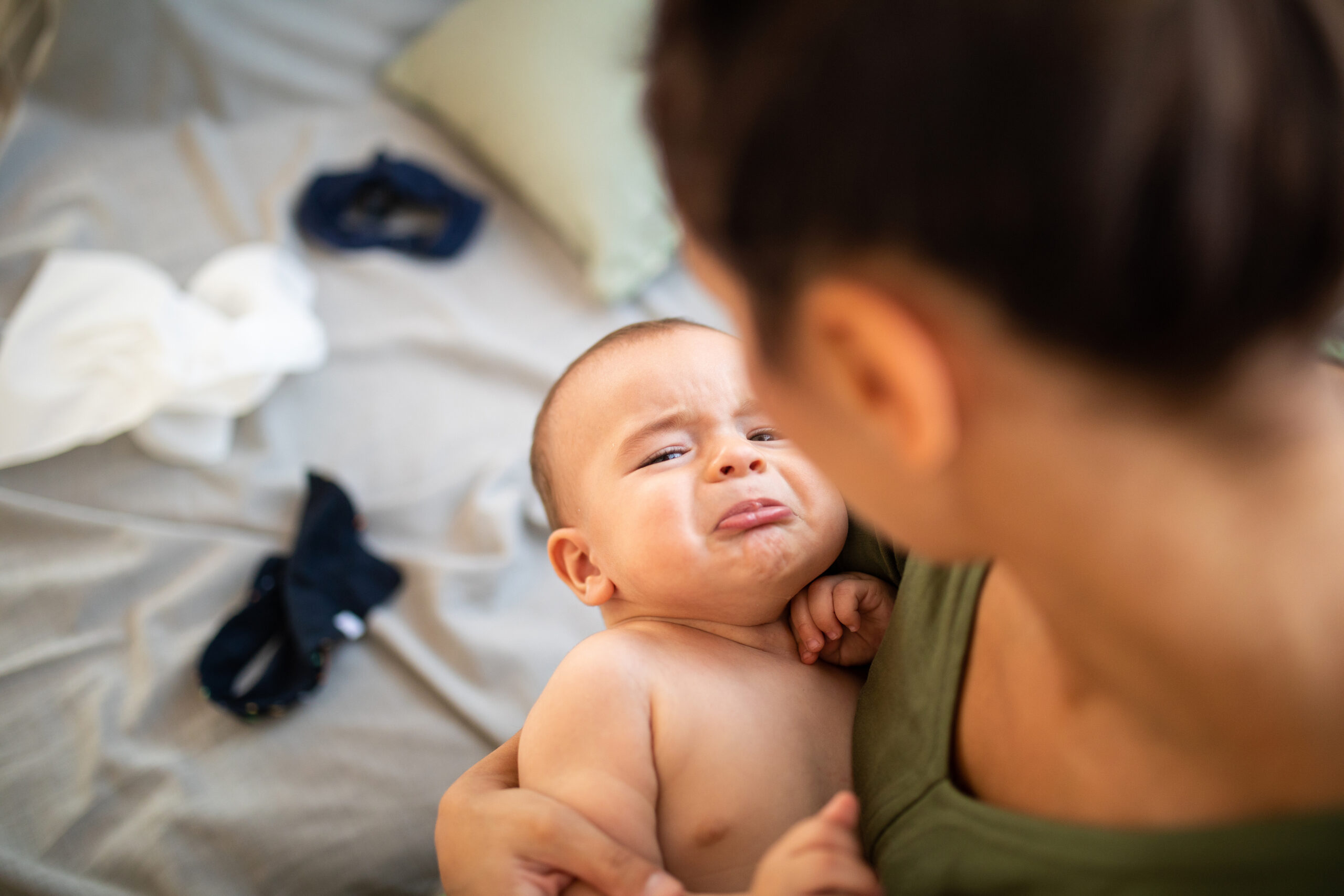 Crying baby boy in mother's arms