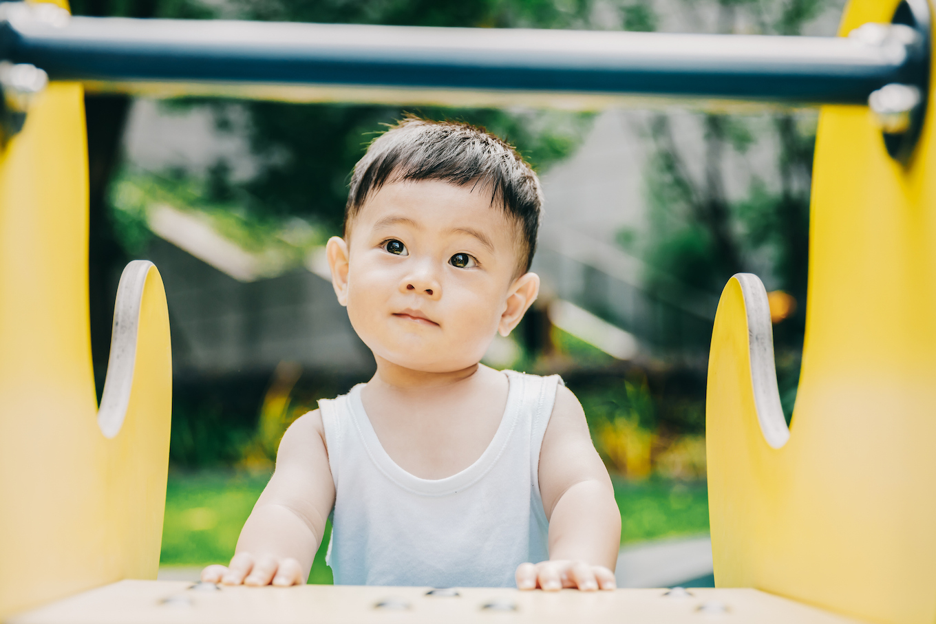 Asian baby is playing outside.