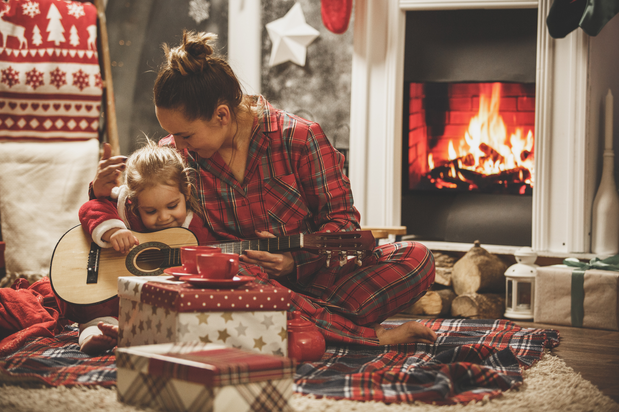 Mother and daughter playing guitar together on a Christmas Eve