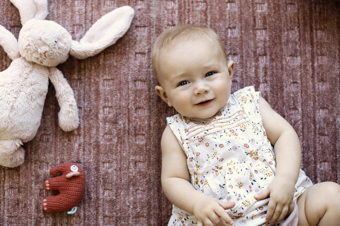 Portrait of cute baby girl lying with toy animals