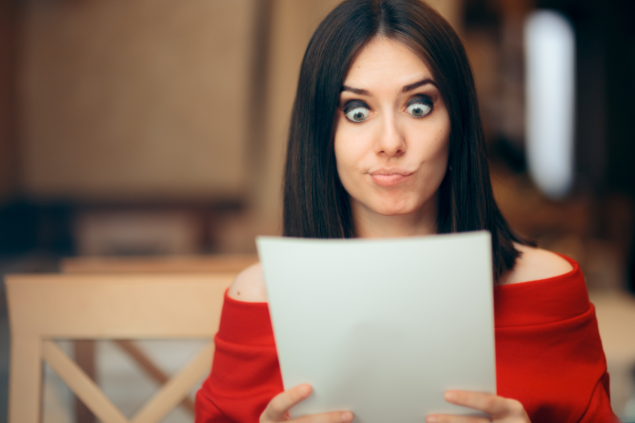 Surprised Woman Reading Legal Documents in a Restaurant