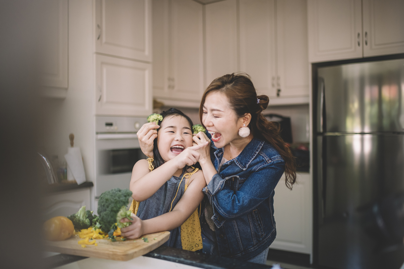 An Asian Chinese housewife having bonding time with her daughter in kitchen preparing food