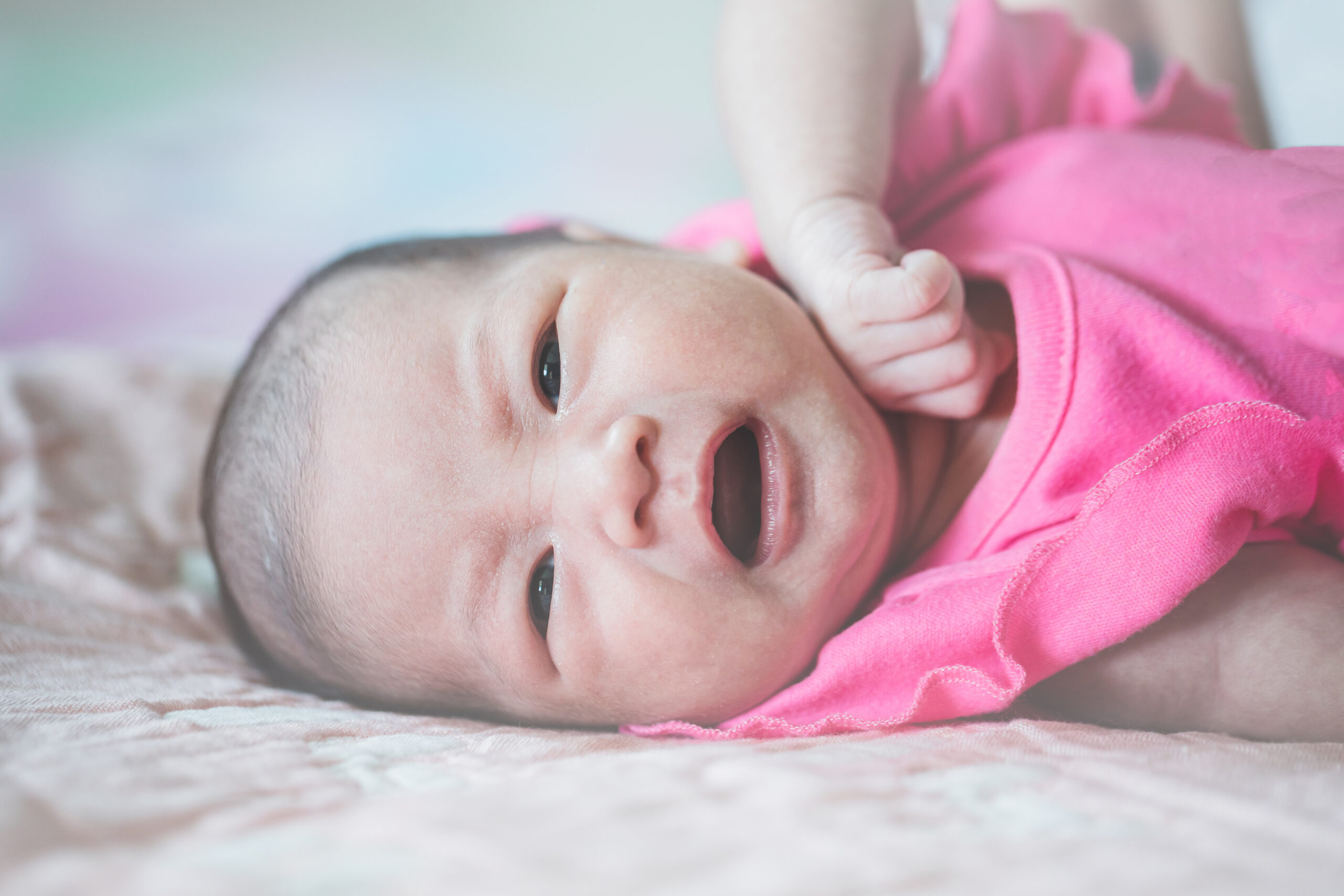 The infant is crying and lying