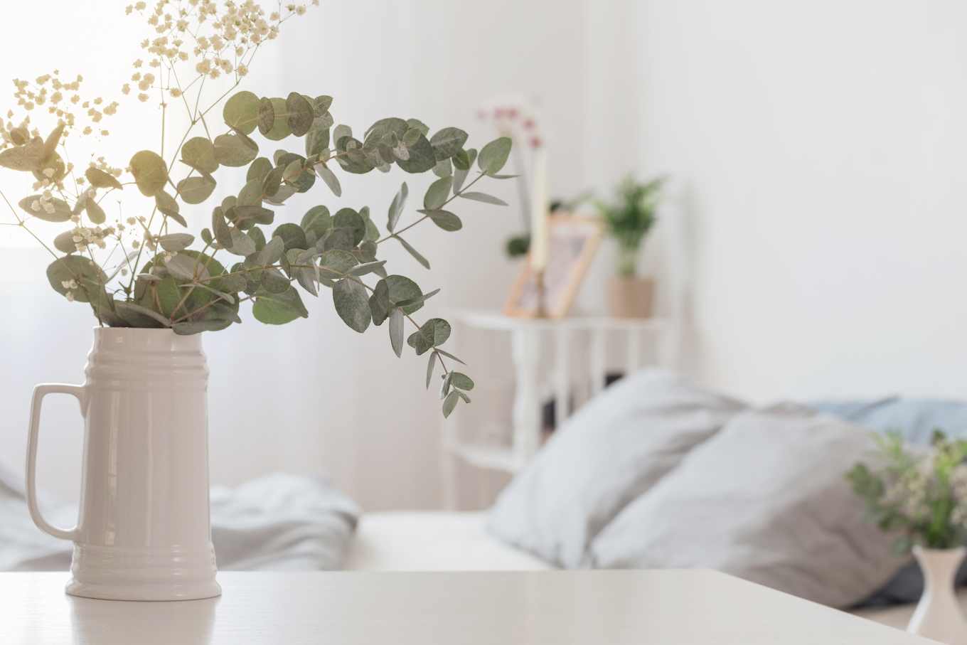 eucalyptus and gypsophila in jug in white bedroom