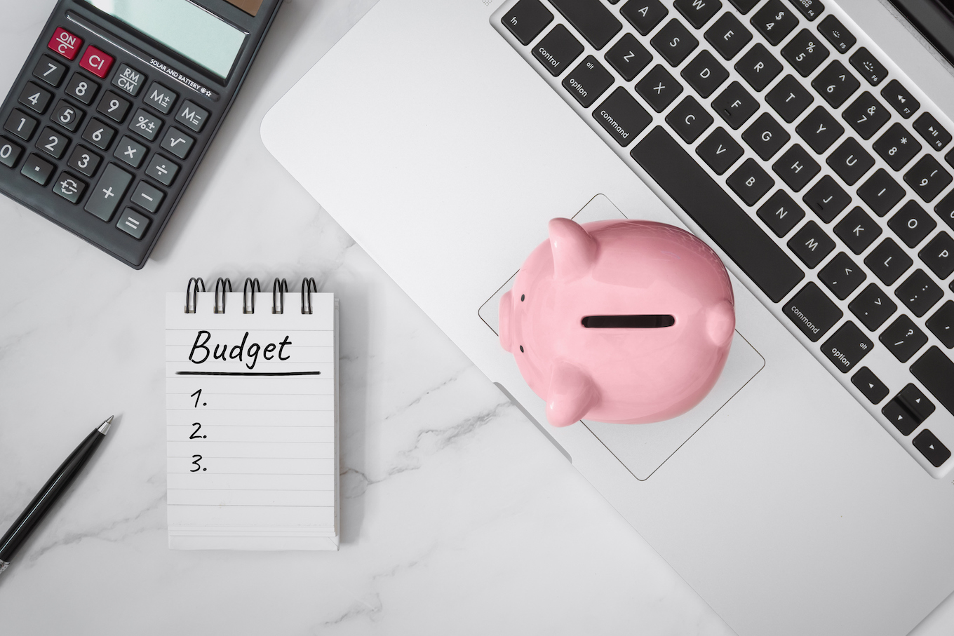 Notebook and Piggy Bank on Laptop