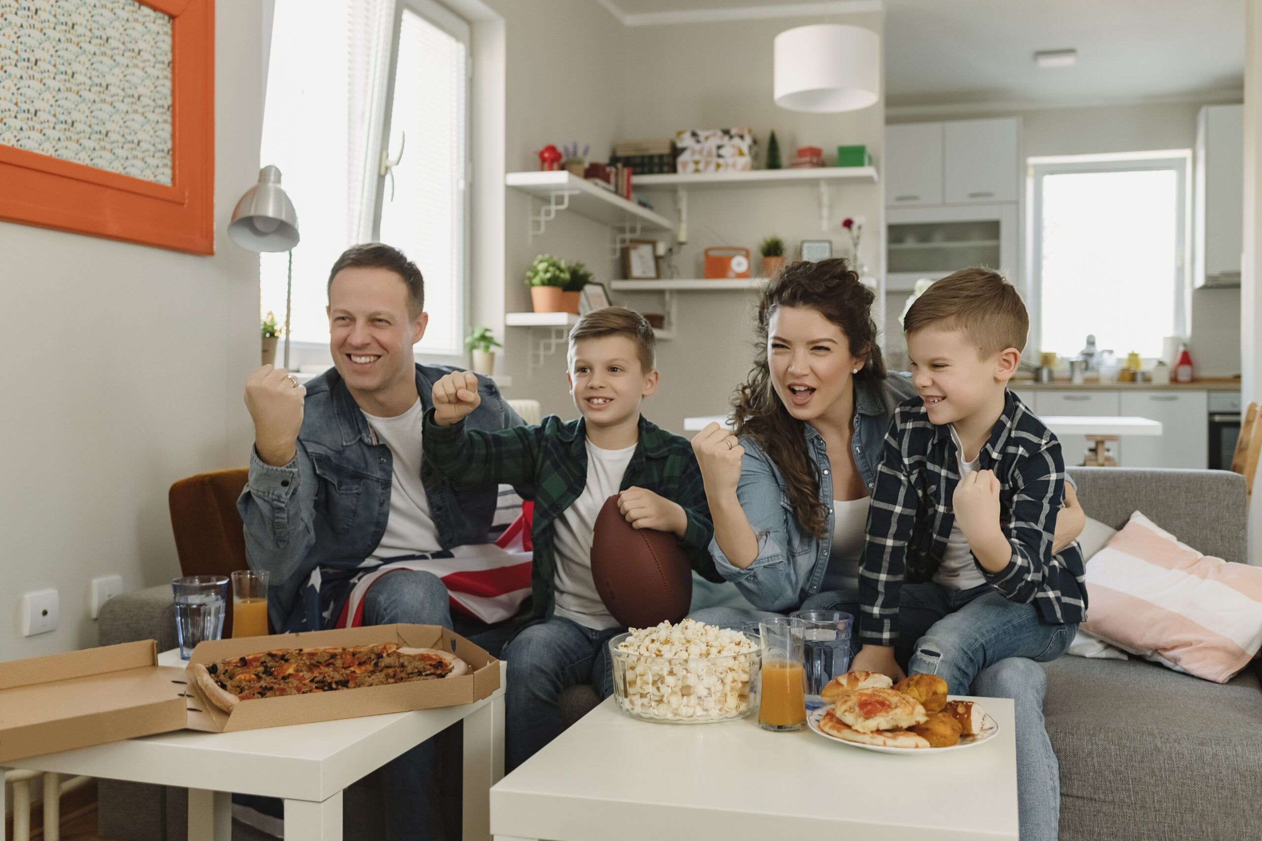 Family Watching Sports On Television And Cheering