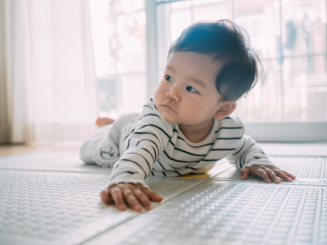 Baby boy smiling and laughing on the mat.