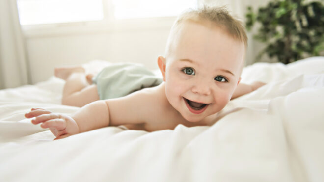 happy baby boy on bed