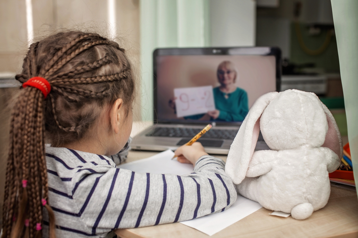Pretty stylish schoolgirl studying math during her online lesson at home, self-isolation