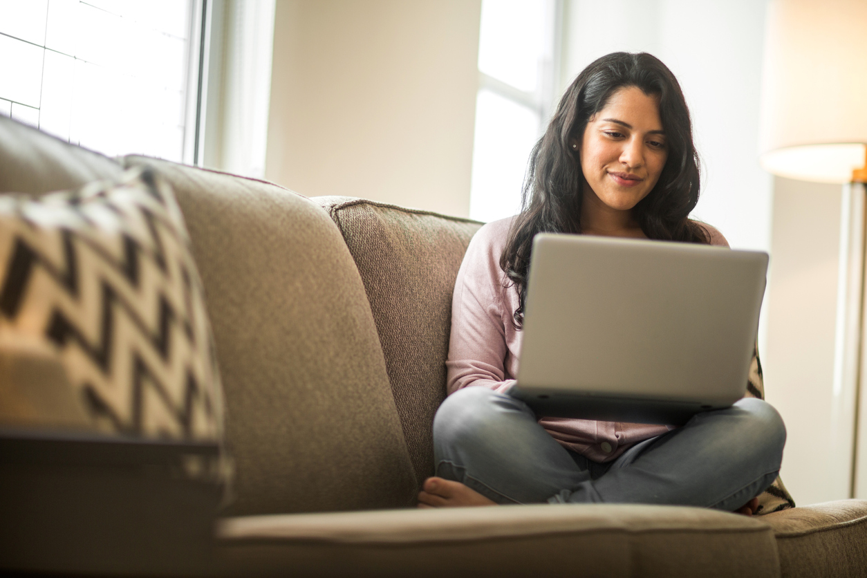 Hispanic woman at home working on a computer.