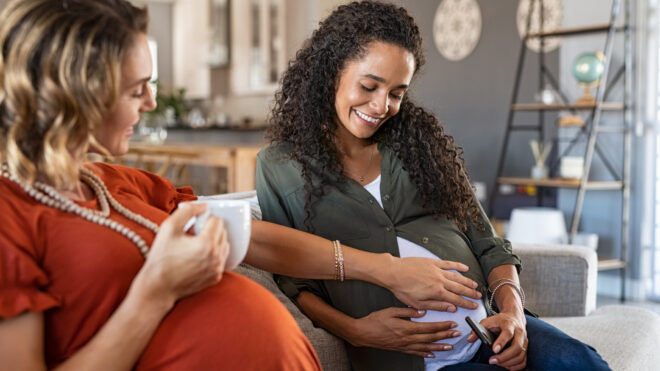 two pregnant women sit together