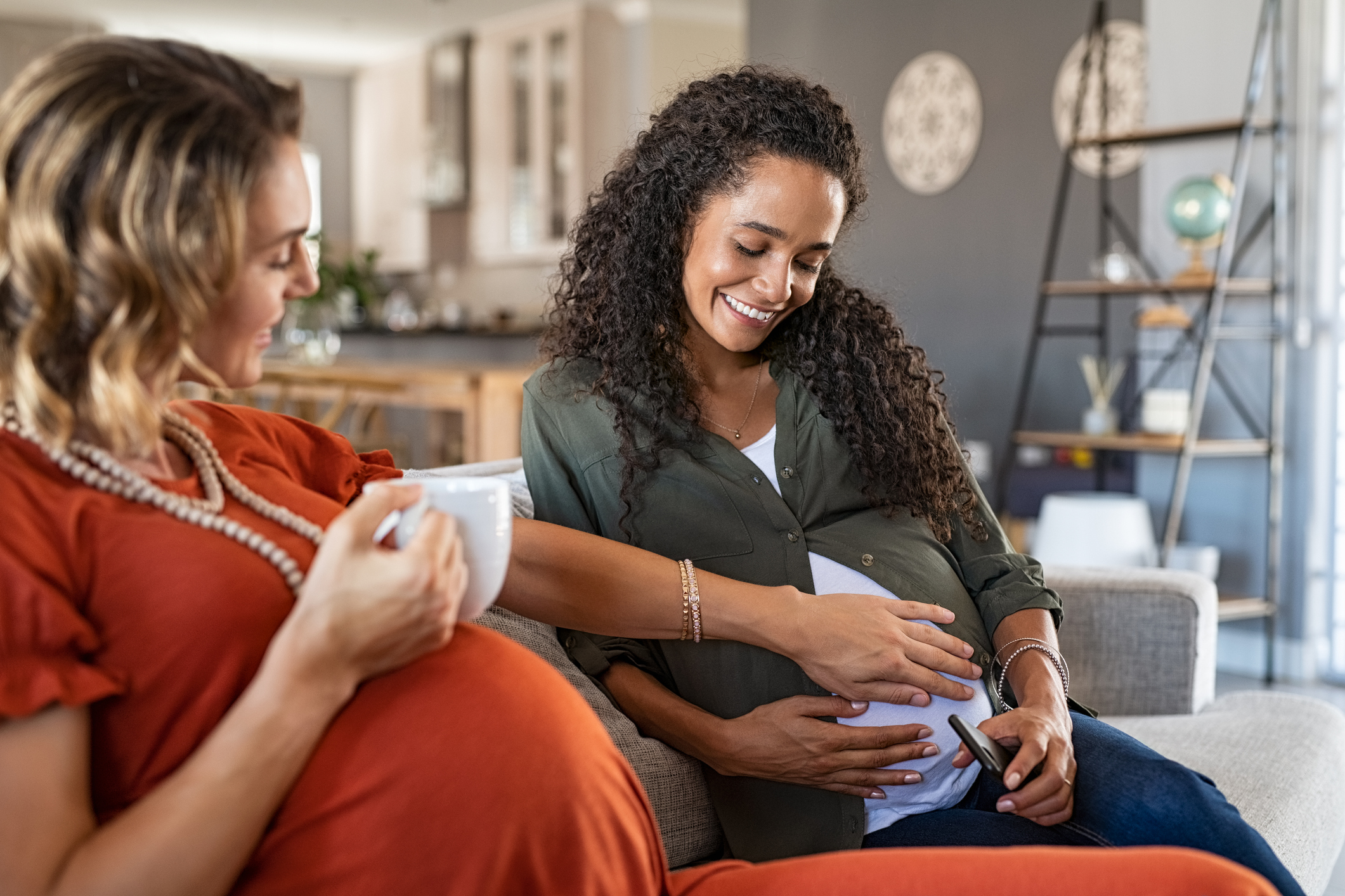 two pregnant women sit together