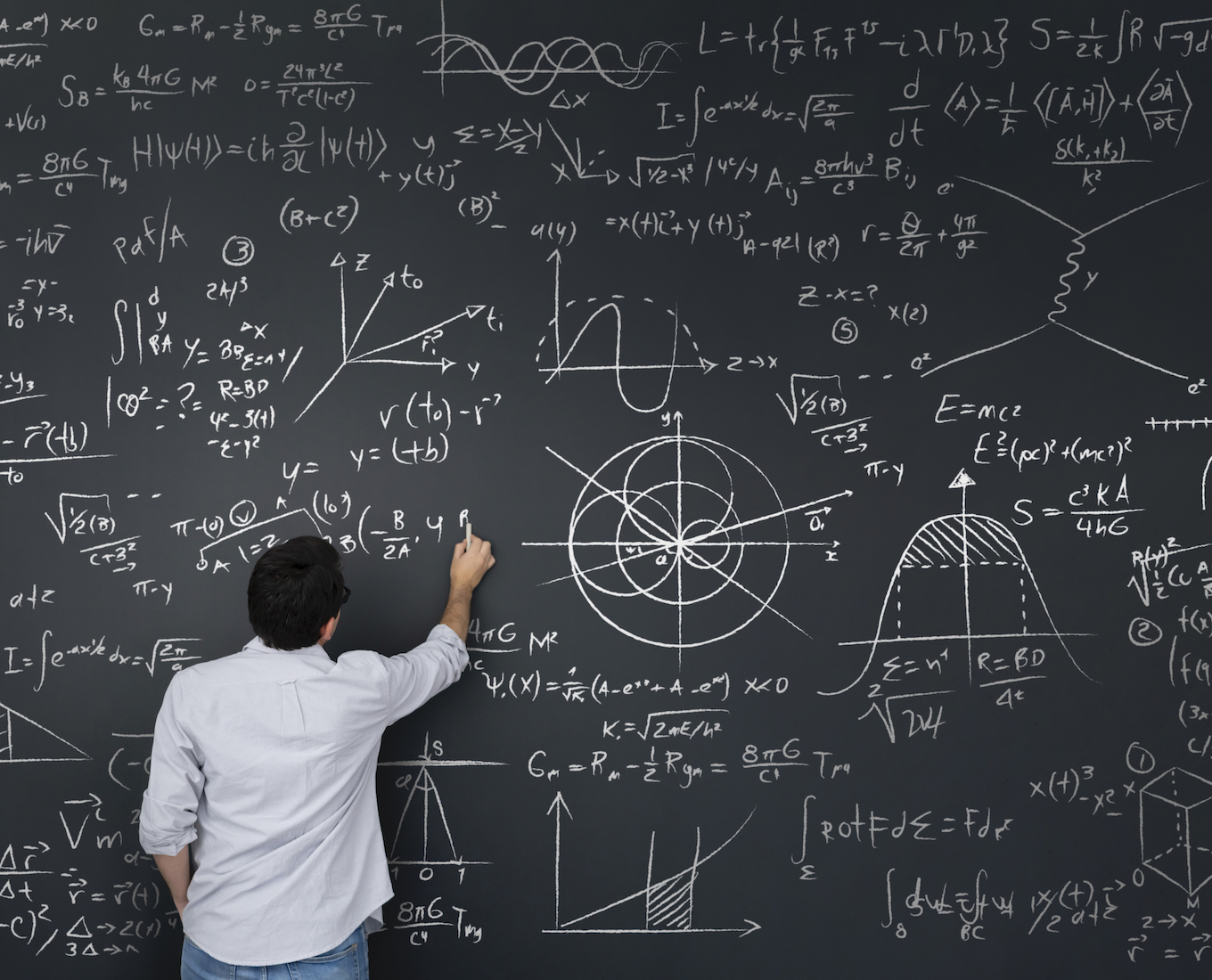 Physics teacher writing math equations on a blackboard