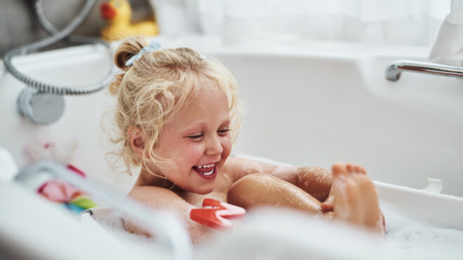 Little girl bathing in a tub.