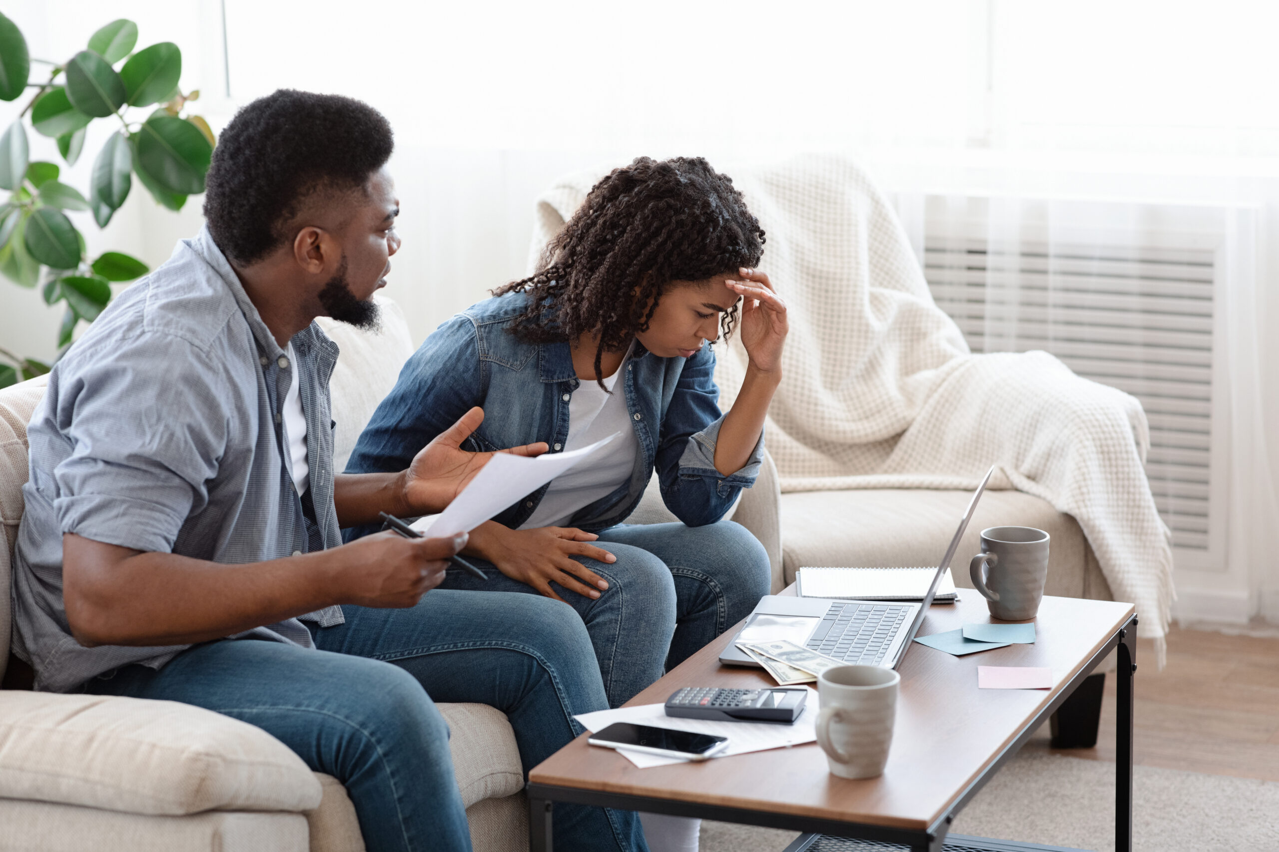 Spouses accounting family budget at home, husband scolding wife for overspending Spouses accounting family budget at home, husband scolding wife for overspending