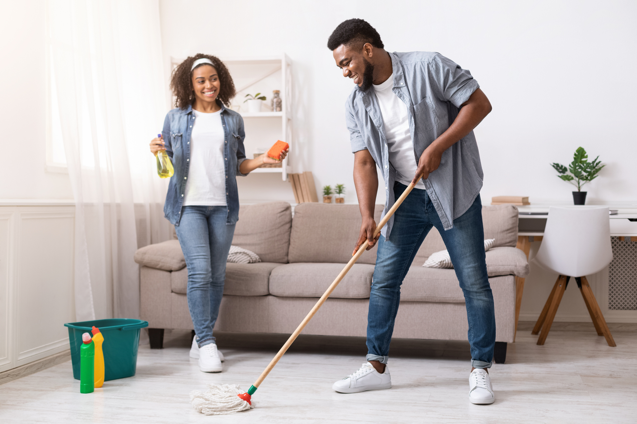 Household Concept. Happy Black Couple Enjoying Cleaning House Together
