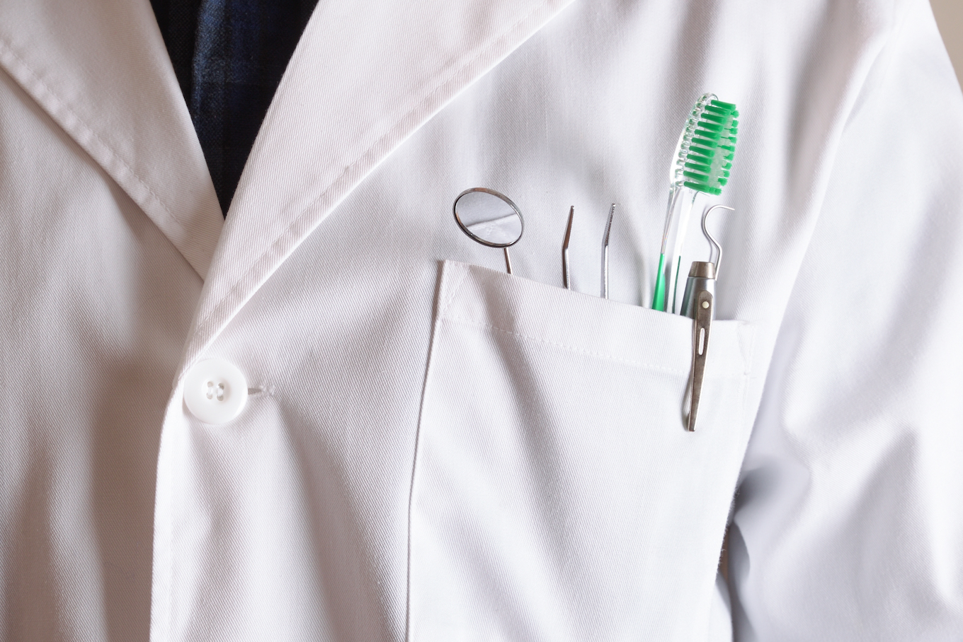 White coat of dentist with tools in his pocket