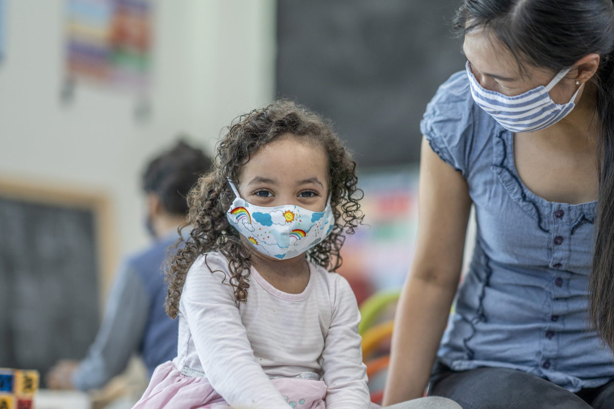4 year old girl wearing a protective face mask at daycare