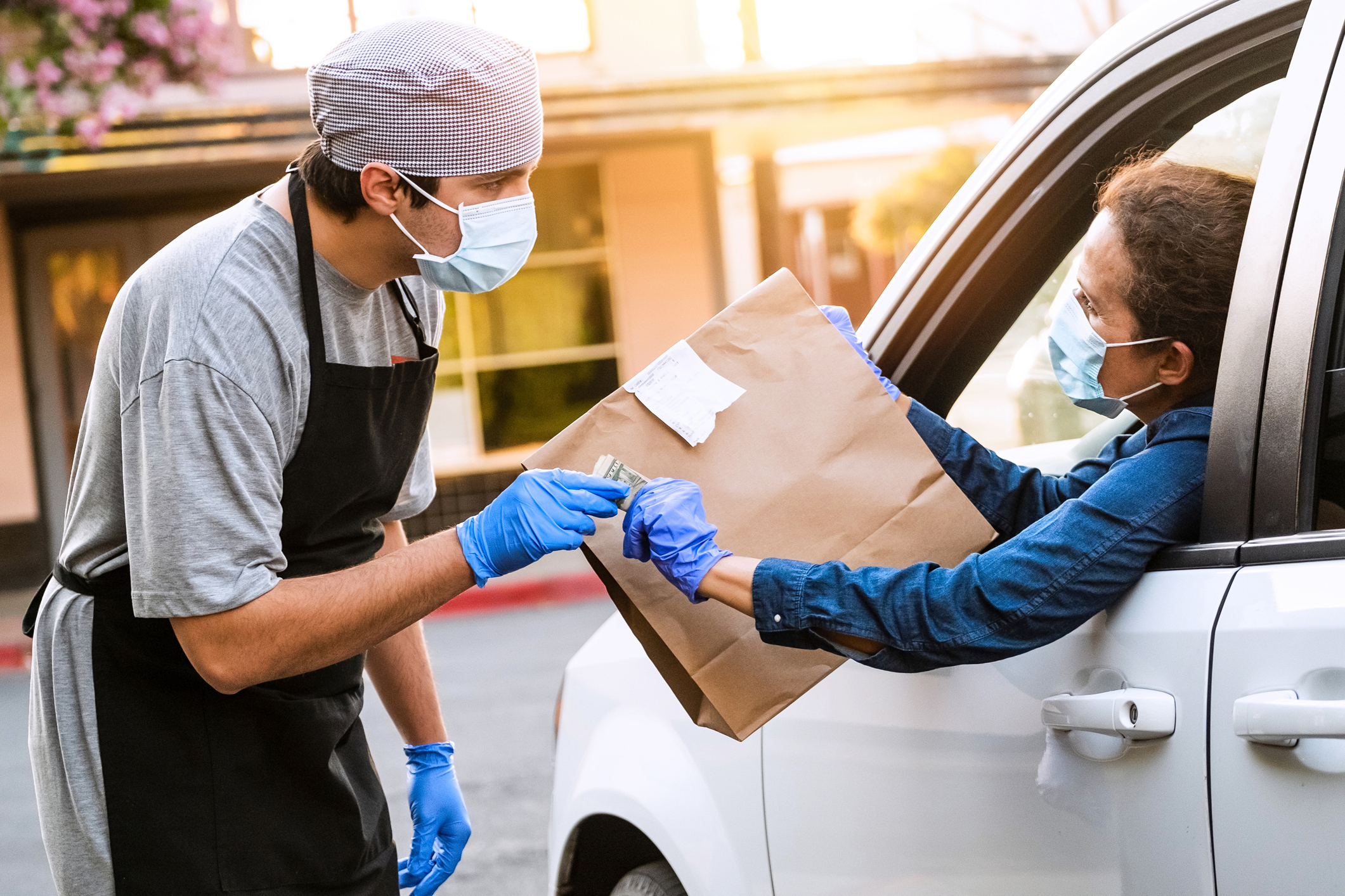 Mature woman picking her restaurant food from her car at a Curbside pickup
