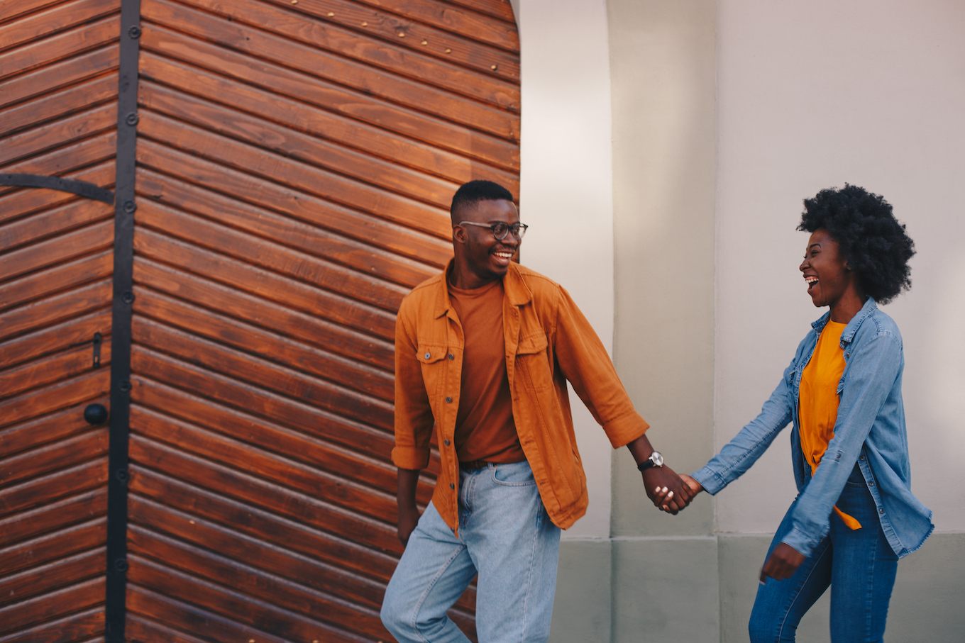 Young handsome hipster african couple walking outdoors and holding hands.