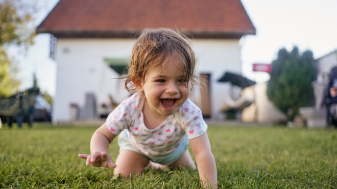 baby girl crawling in the grass