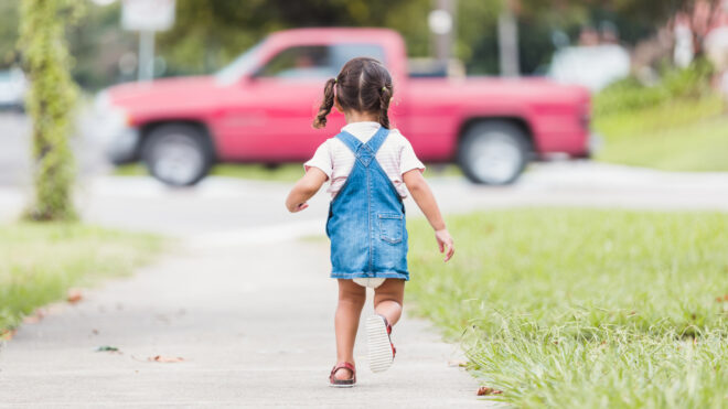 Little girl running towards street