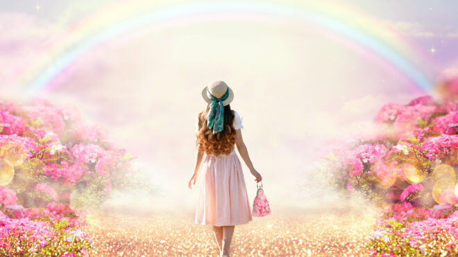 woman walking through beautiful sprig field and rainbows