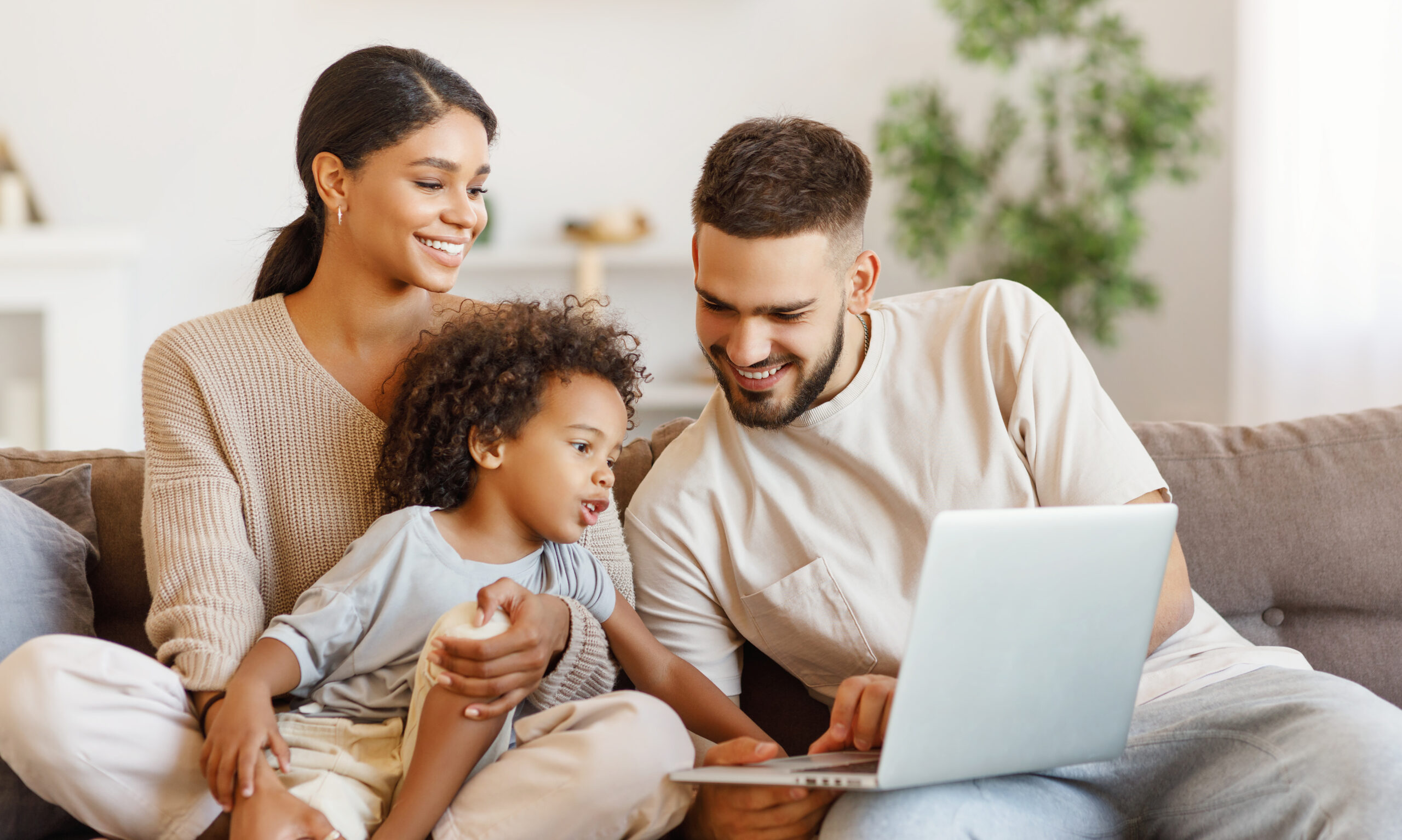 Diverse family using laptop on sofa together