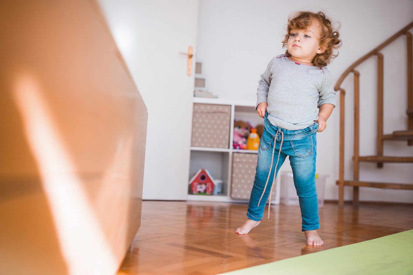 Adorable baby girl pulling up her pants