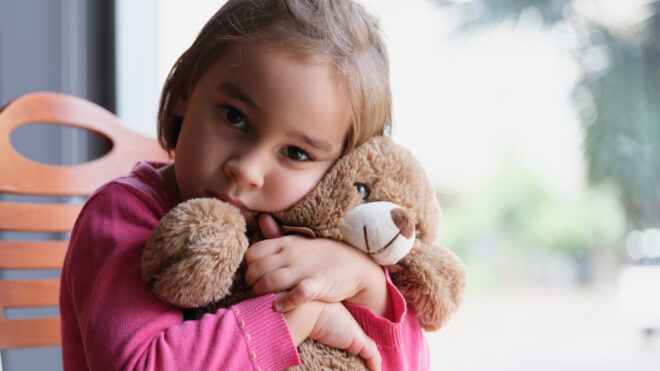 girl hugging stuffed animal