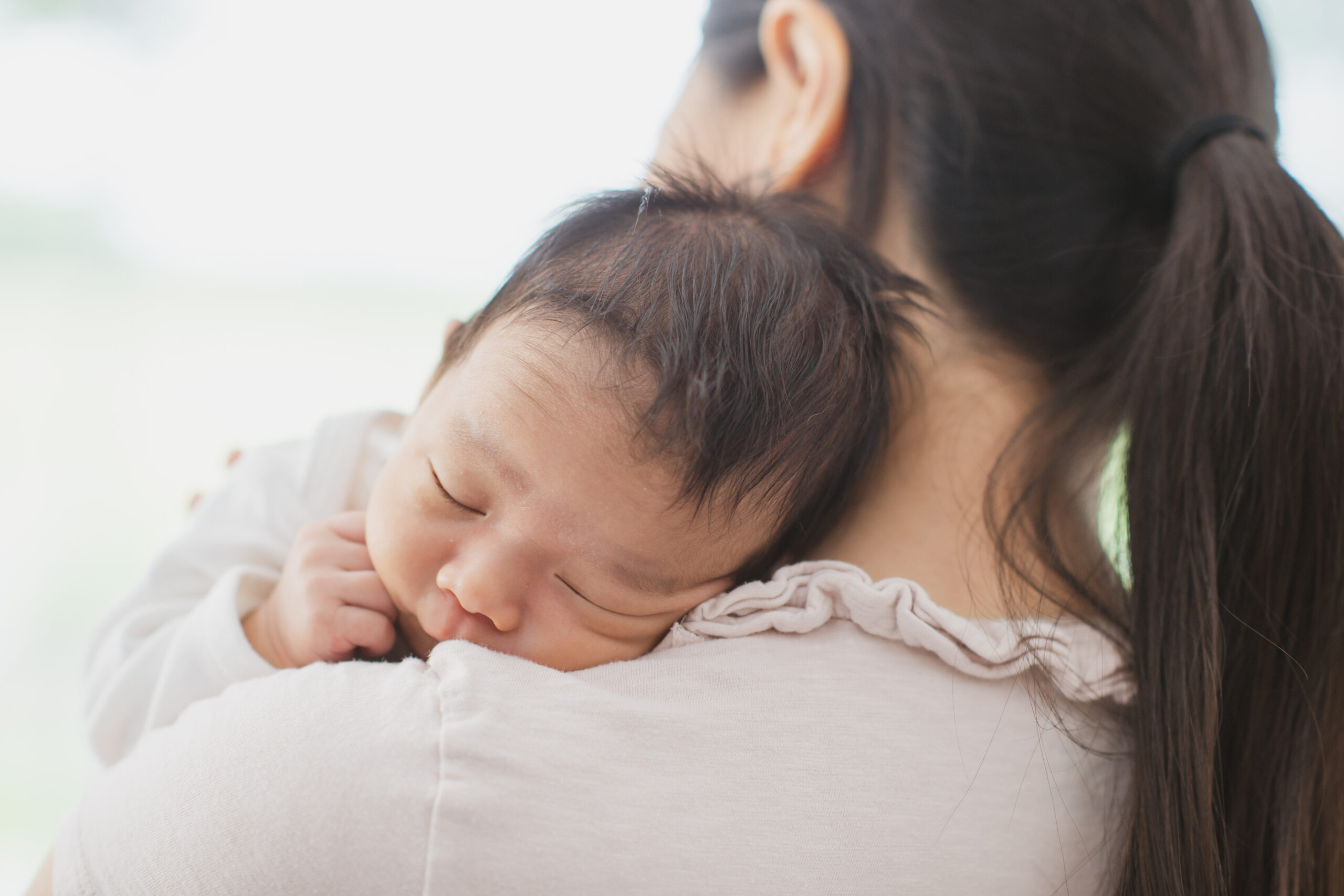 Mother holding sleepy newborn