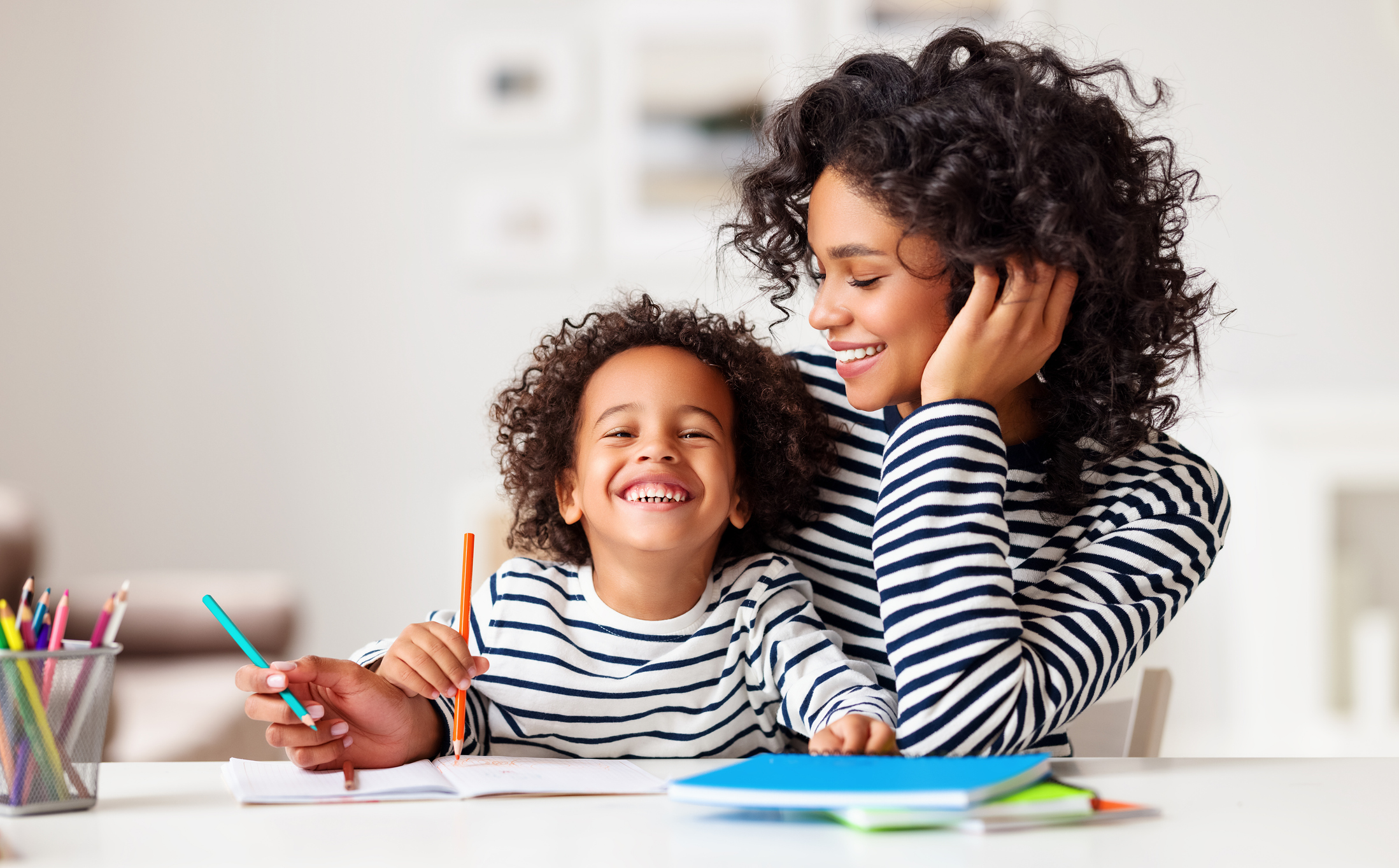 Excited ethnic mother and son doing homework